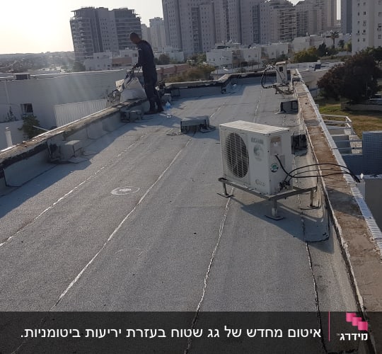 אדם עובד על איטום גג עם יריעות ביטומניות